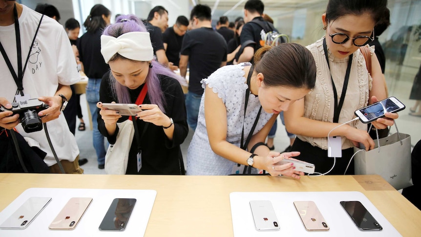 Women looking at an iPhone display in an Apple store