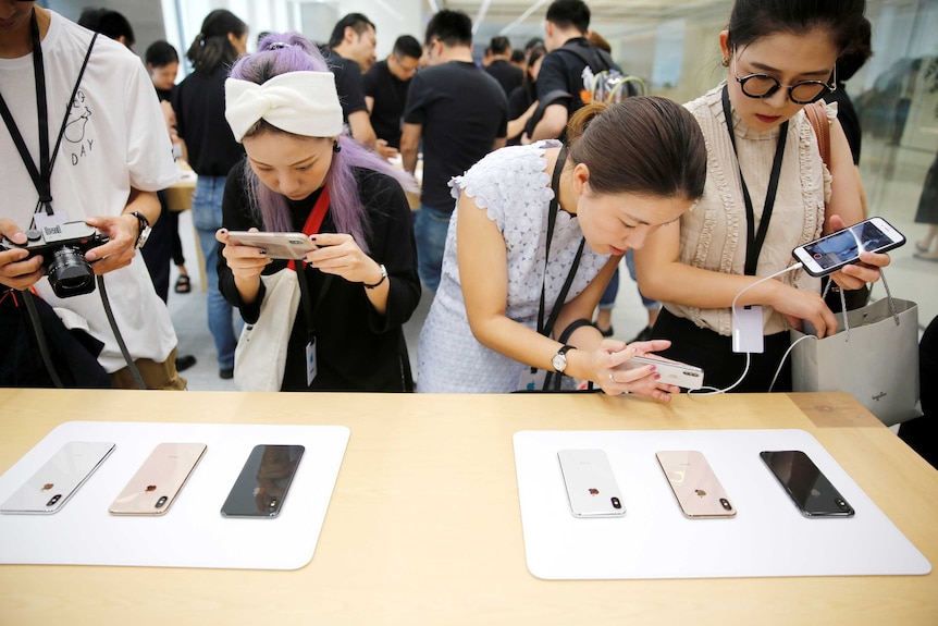 Women looking at an iPhone display in an Apple store
