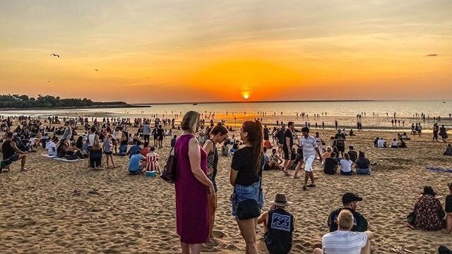 A photo of crowds gathering as the sun sets over the Mindil Beach Sunset Markets.