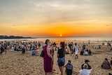 A photo of crowds gathering as the sun sets over the Mindil Beach Sunset Markets.