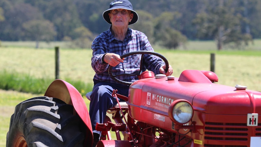 A man driving an antique tractor