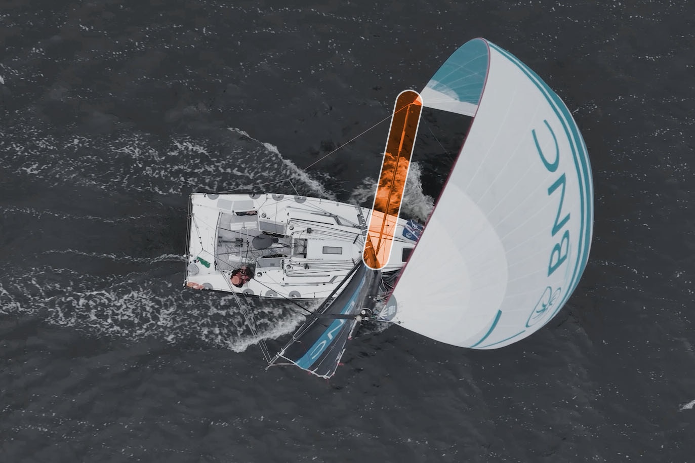 Un poste resaltado en naranja que sostiene la vela de un yate fuera del barco.