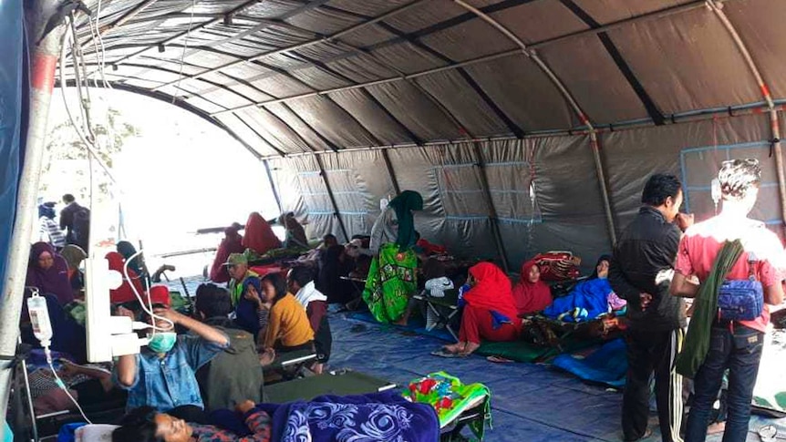 Earthquake survivors receive medical treatment at a temporary shelter