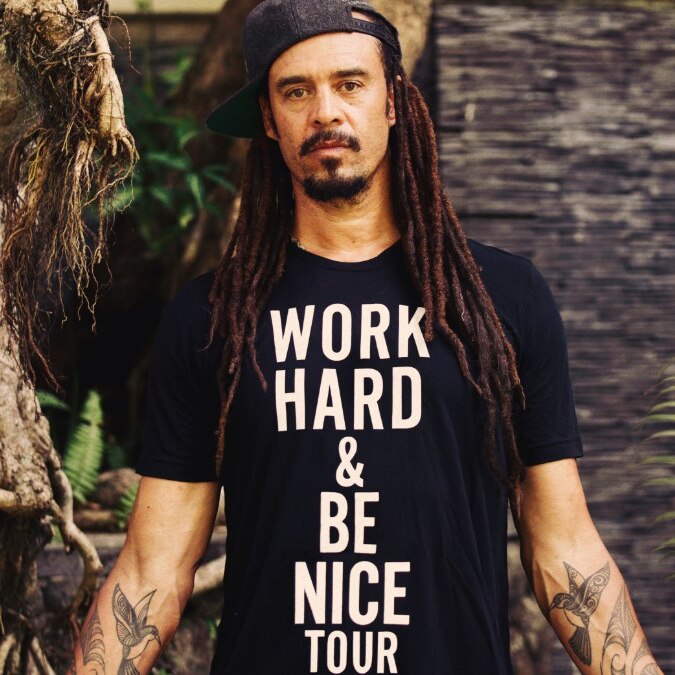 Songwriter Michael Franti wearing a shirt that says work hard and be nice