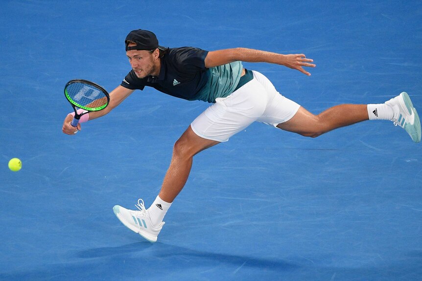 A tennis player stretches to hit a forehand on Rod Laver Arena at the Australian Open.