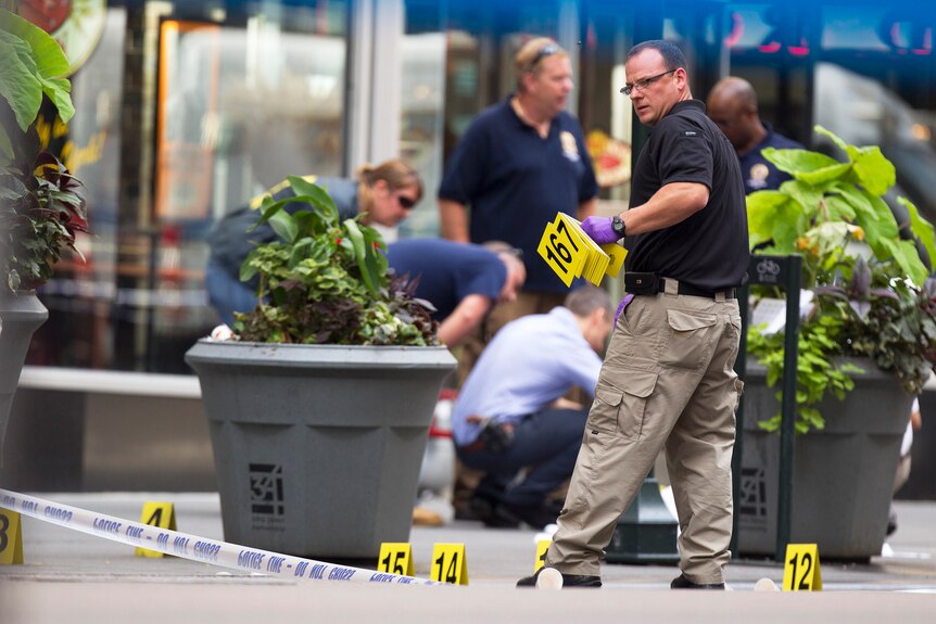 A police officer places markers denoting spent shell casings after a shooting at the Empire State Building in New York.