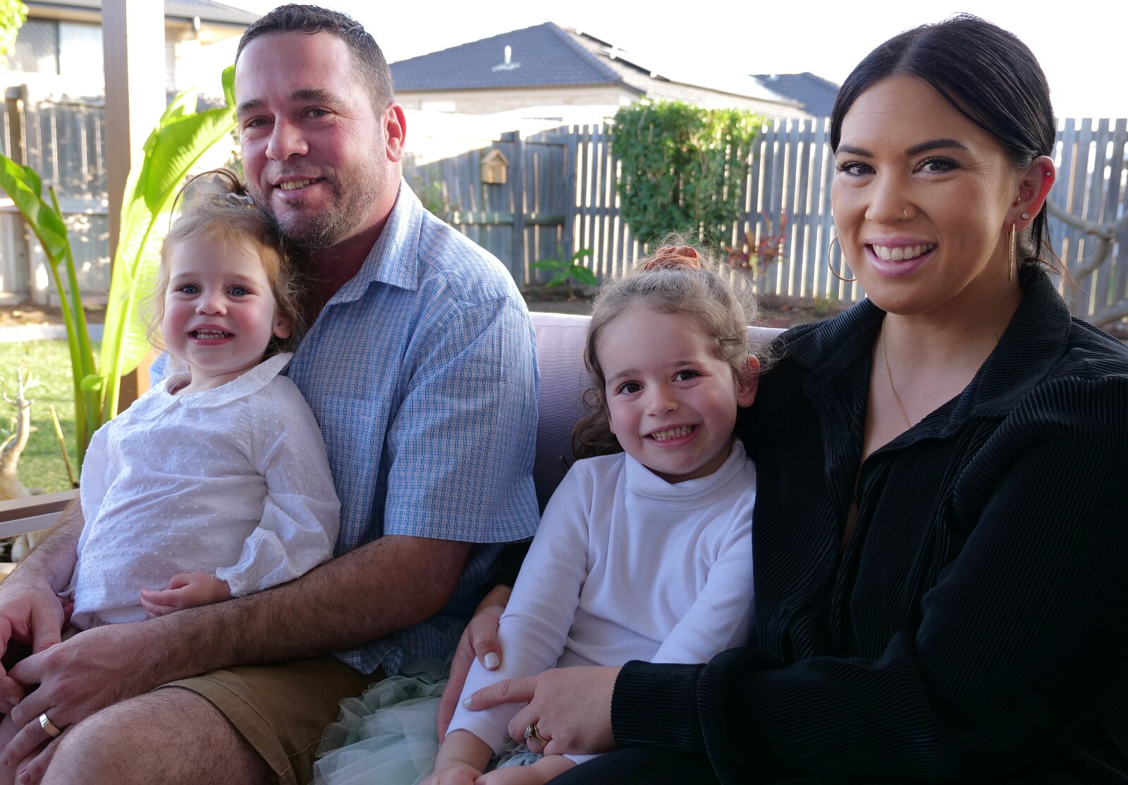 Clay, Ange, Arlo and Bank all sitting together in their backyard.