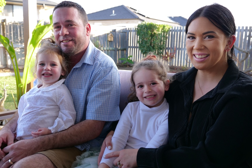 Clay, Ange, Arlo and Bank all sitting together in their backyard.