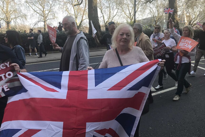 A woman holds a Union Jack flag as pro-Brexit protesters take to the streets