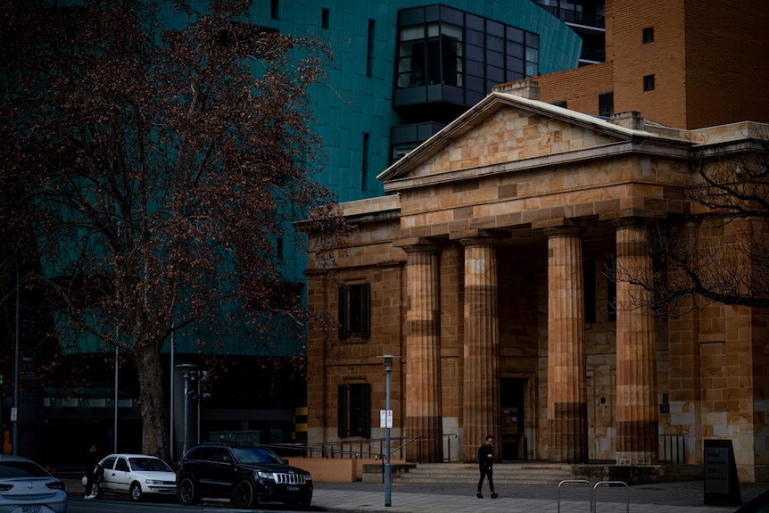 A court build with a columned verandah and a blue coloured building behind