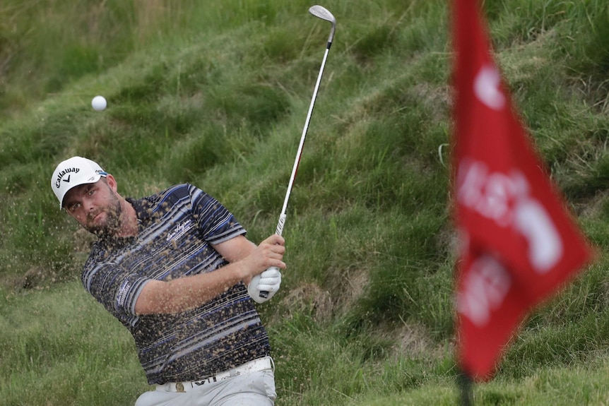 Marc Leishman hits from a bunker on the 16th hole at Erin Hills.