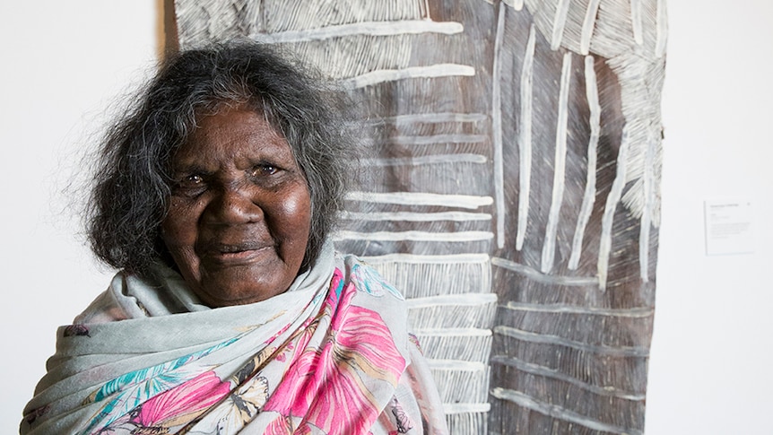 Nyapanyapa Yunupingu in front of her artwork on bark.