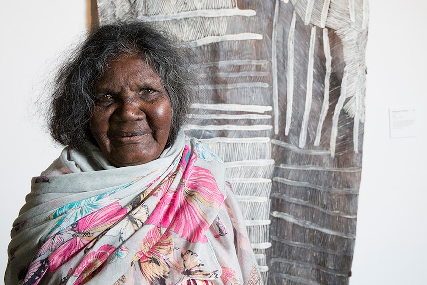 Nyapanyapa Yunupingu in front of her artwork on bark.