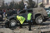 Afghan security personnel inspect the site of a roadside bomb blast in Kabul, Afghanistan