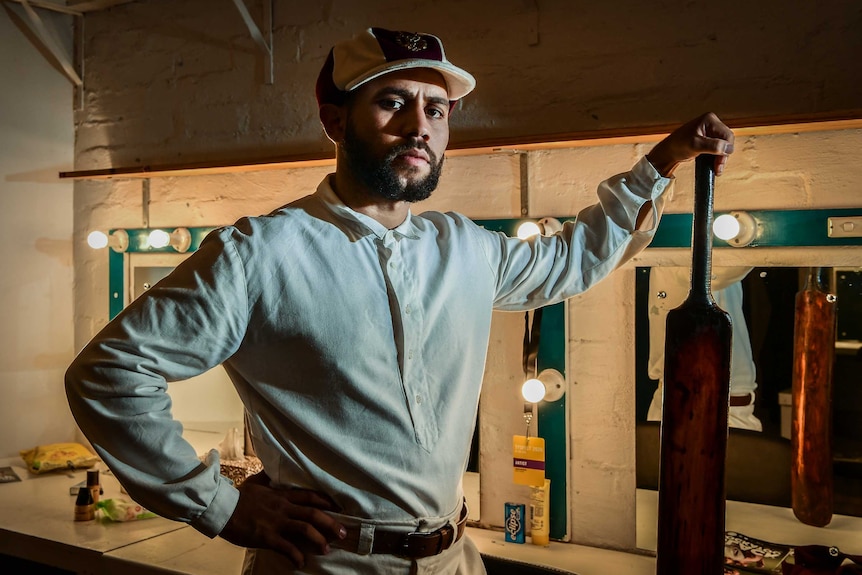 Aaron McGrath in cricket whites with an old-school cricket bat