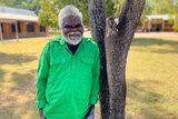 A senior aboriginal man wearing a bright green collared shirt.