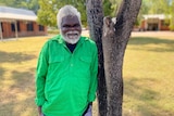 A senior aboriginal man wearing a bright green collared shirt.