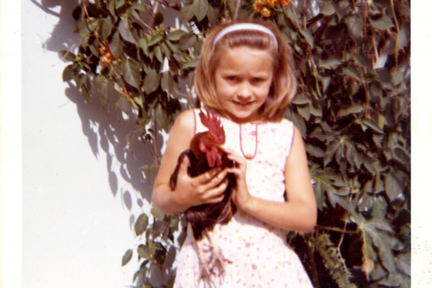 Collette Dinnigan as a young girl, holding a chicken.