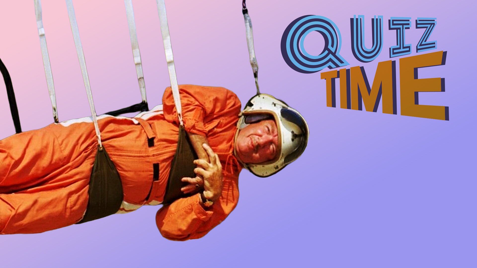 Astronaut in orange suit and helmet hangs horizontally from straps.