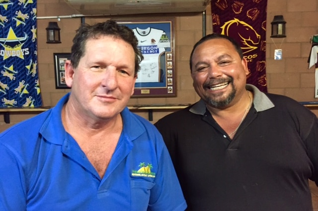 Two men sitting at the bar with Australian rugby league flags behind them.