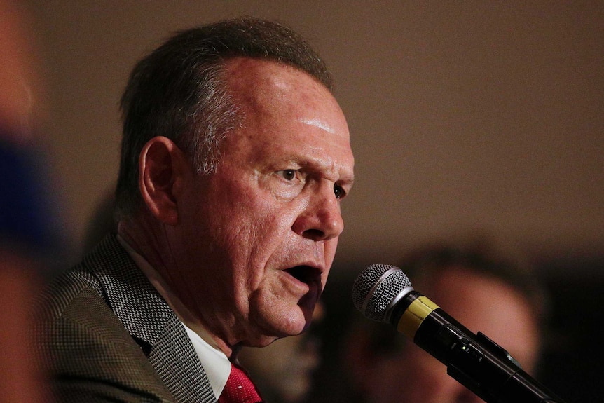 Judge Roy Moore speaks into the microphone at his victory party in Alabama.