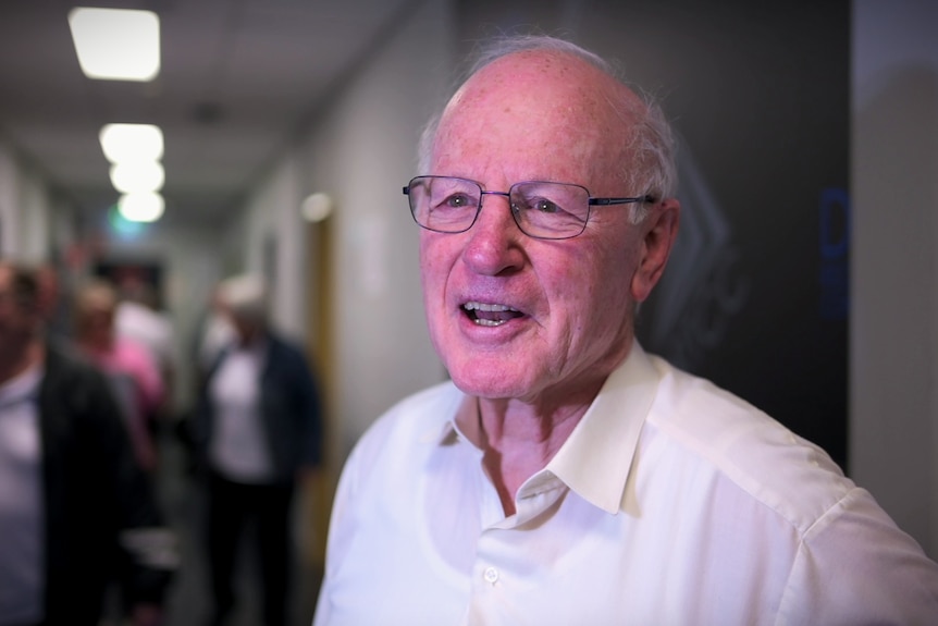 A elderly man in a hallway