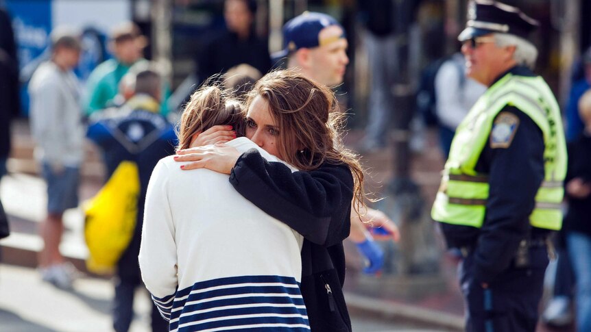 A woman comforts another after explosions at the Boston Marathon.
