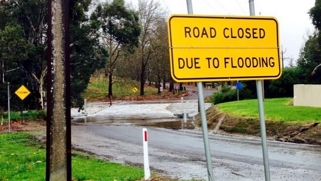 Heavy rain is causing some flood issues in the Adelaide Hills, including water from the Onkaparinga River covering this road.