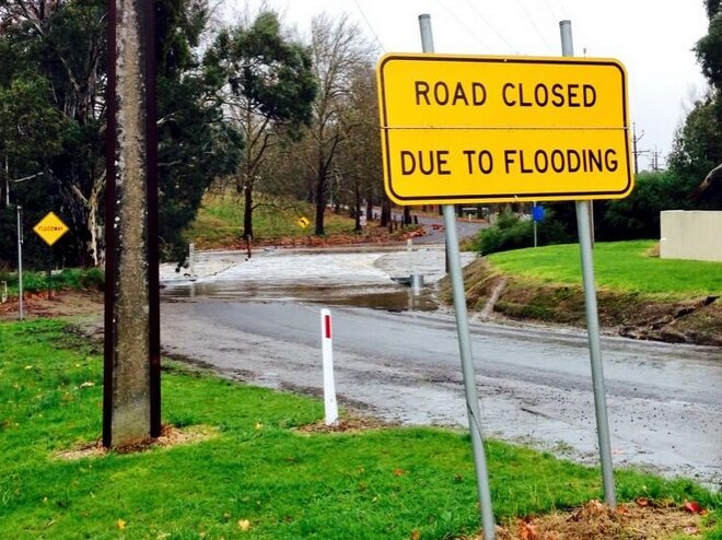 Heavy rain is causing some flood issues in the Adelaide Hills, including water from the Onkaparinga River covering this road.