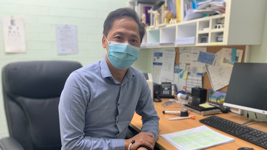 Dr Vinh Lao sitting at his desk in surgery