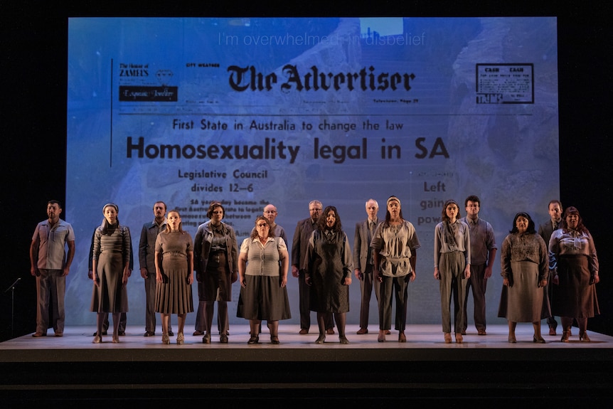 A chorus of people dressed in 70s-style clothing stand on stage, in front of an image of The Advertiser newspaper