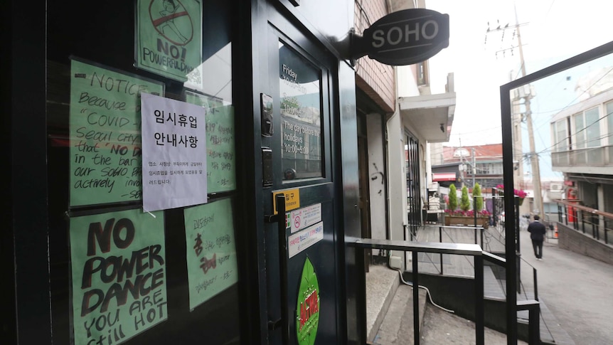 Signs posted on a closed door with messages such as 'NO POWER DANCE - YOU ARE STILL HOT'