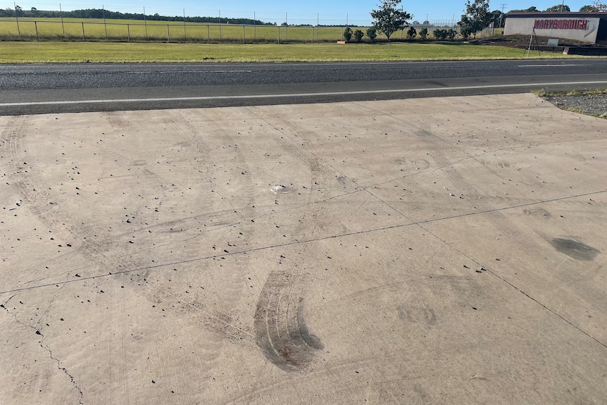 Rubber marks on white concrete beside road 