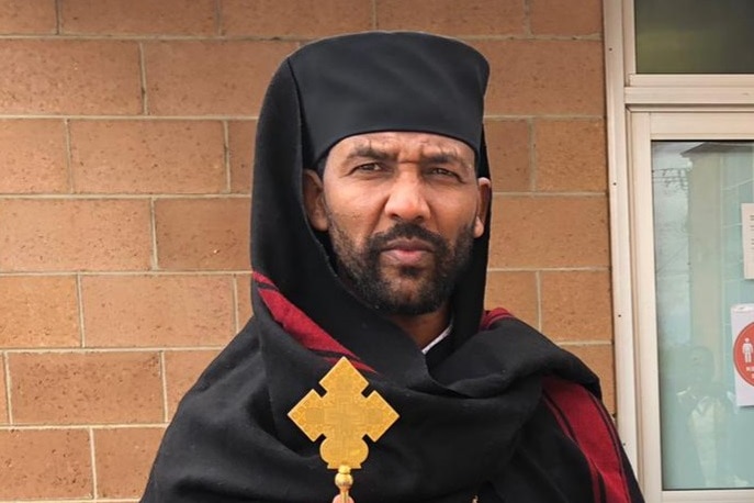 A man stands in traditional Ethiopian Orthodox priest attire