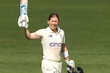 Heather Knight holds the bat up with her helmet off