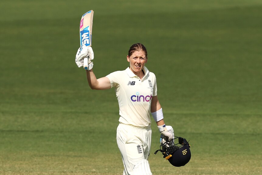 Heather Knight holds the bat up with her helmet off