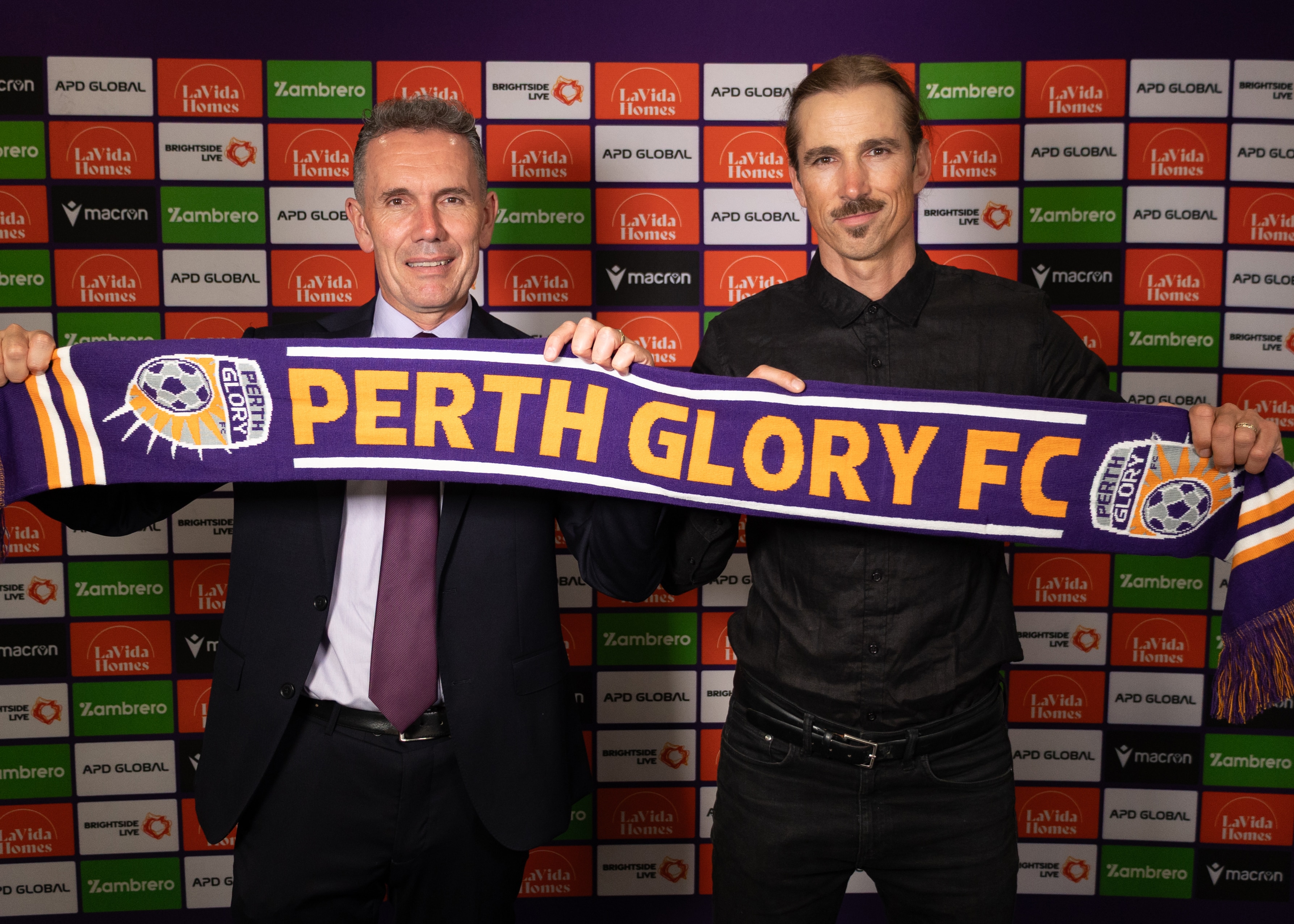 O técnico do Perth Glory, Adam Griffiths, e o executivo-chefe Anthony Radich posam para uma foto segurando um lenço do Glory.