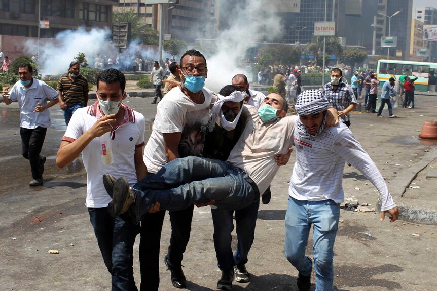 An injured protester is carried away after clashes in Cairo