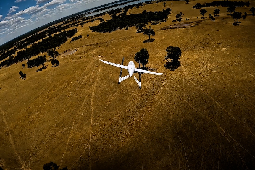 A delivery drone flying over regional Australia.