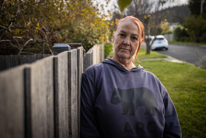 Trish Bone leans against a fence.