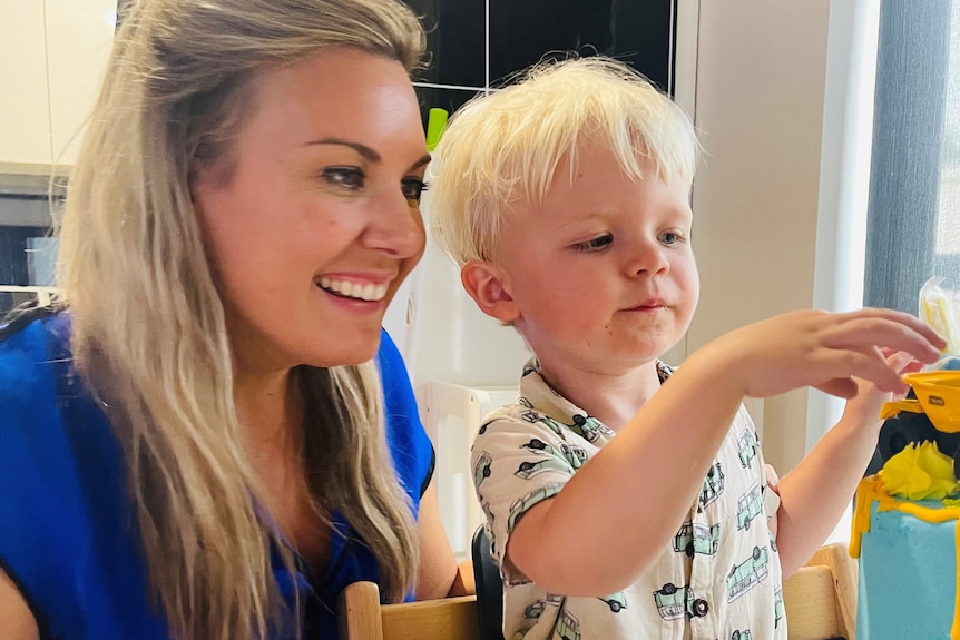 A boy and his mother play at a table.