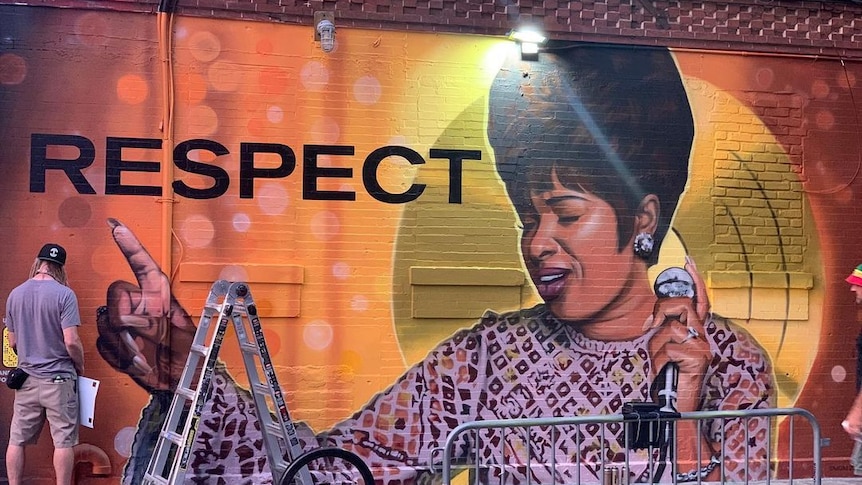 A mural of Aretha Franklin with the word 'respect' painted on it.