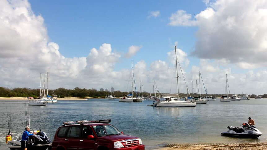 A red car backing a jet ski into the water on a sunny day at the Broadwater.