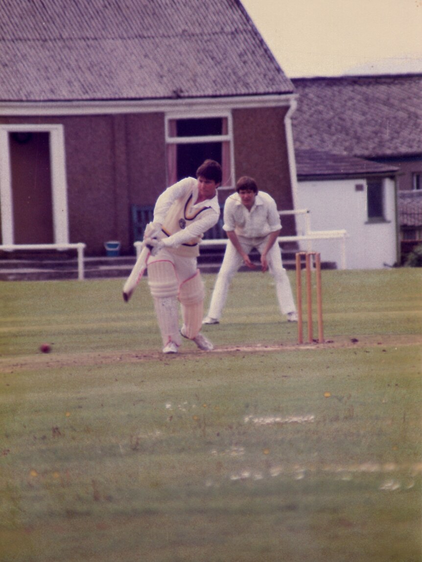 A cricket plays a drive down the pitch