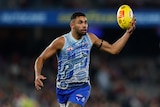 An AFL player looks to move the ball