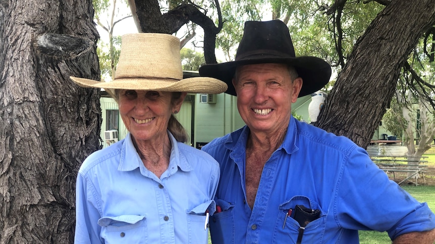 a man and womna in blue work shirts and wearing cattle hats