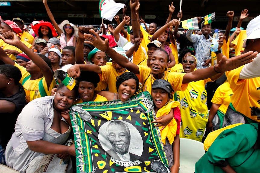 ANC supporters hold a picture of former president Thabo Mbeki during the celebrations