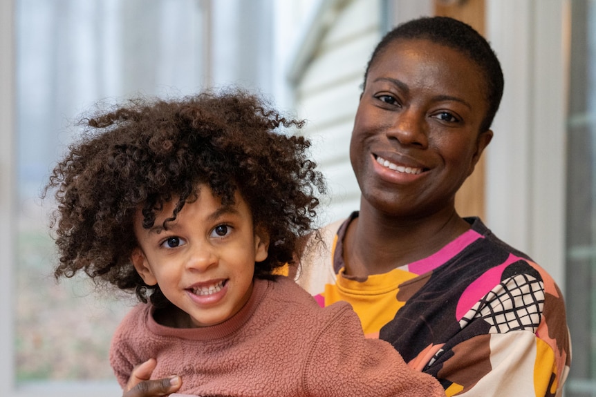 A mother and son smile at the camera