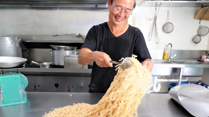 Shing Hee Ting tossing freshly cooked noodles