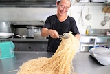 Shing Hee Ting tossing freshly cooked noodles
